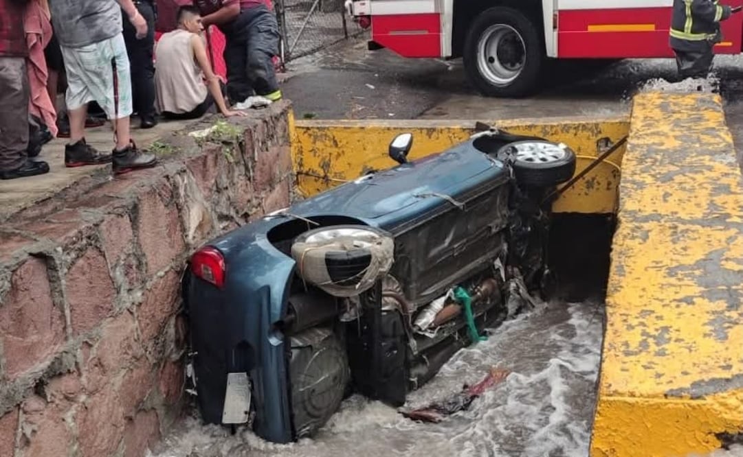 El automóvil compacto quedó recostado sobre su costado izquierdo en medio de la corriente de agua de la colonia Lázaro Cárdenas. Foto Especial