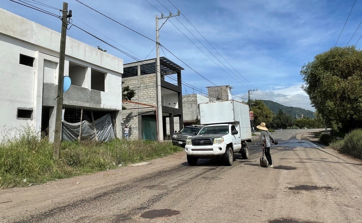 Dos personas con palas y tierra, tapan los baches a cambio de una cooperación voluntaria. Foto: Michelle Sánchez