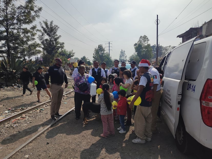 Elementos de seguridad, aún con equipo táctico, se agacharon para entregar personalmente cada regalo a los niños de "Las Vías". Foto Emilio Fernández / El Universal