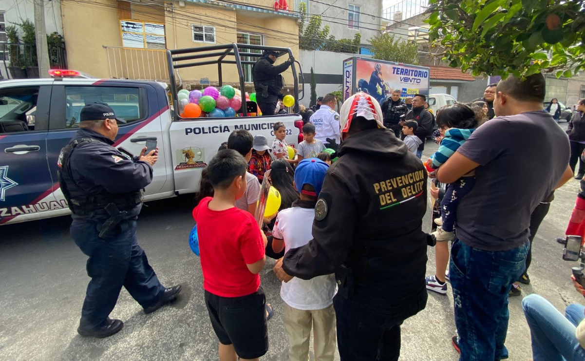 Un niño sonríe al recibir un juguete de manos de un policía municipal de Nezahualcóyotl / Foto: Especial