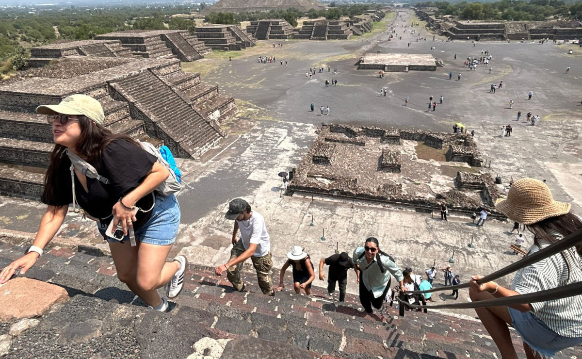 Turistas disfrutan de las vistas desde el primer nivel de la Pirámide de la Luna en Teotihuacán, tras levantarse la restricción parcial. Foto: Especial