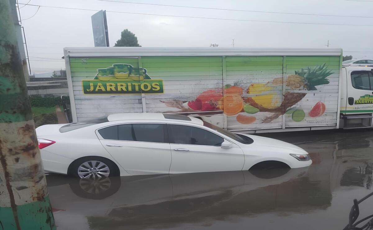 La persona de la tercera edad quedó atrapada al interior de su automóvil al caer en un bache. Foto: Especial