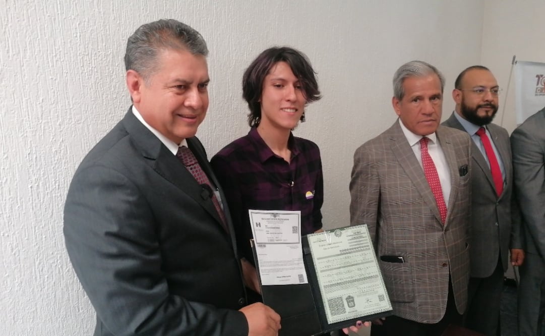 Dany, acompañada por activistas y autoridades, muestra con orgullo la primera acta de nacimiento con reconocimiento de identidad no binaria en el Edomex. Foto Claudia Rodríguez / El Universal
