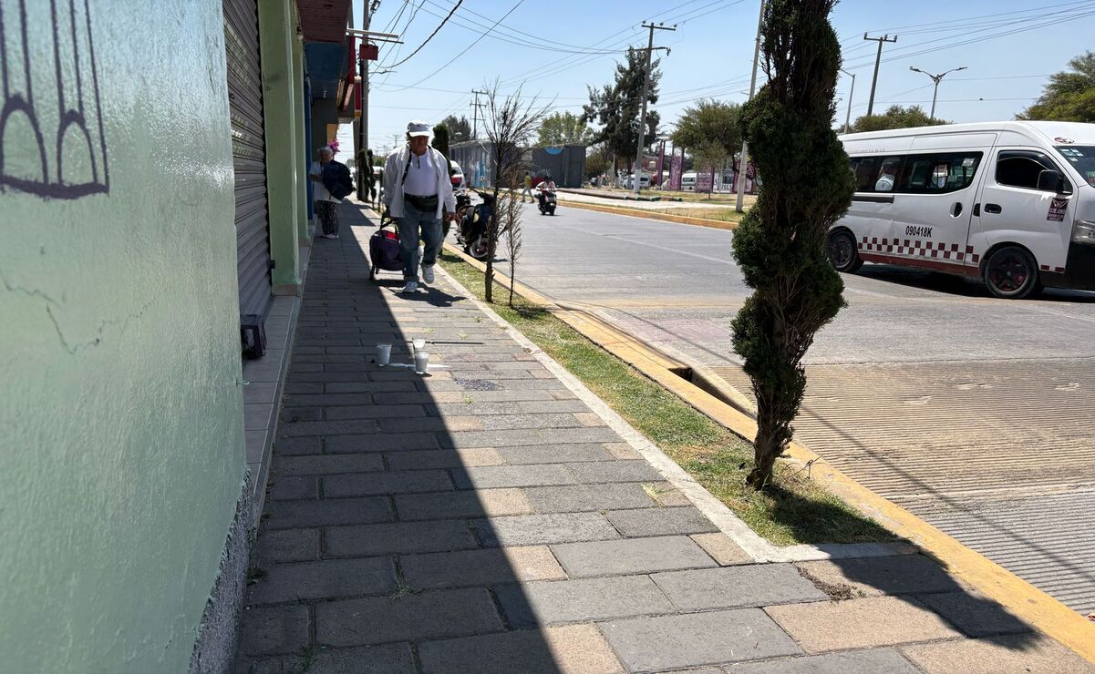 Los clientes del negocio y transeúntes caminan a un costado de las veladoras / Foto Arturo Contreras