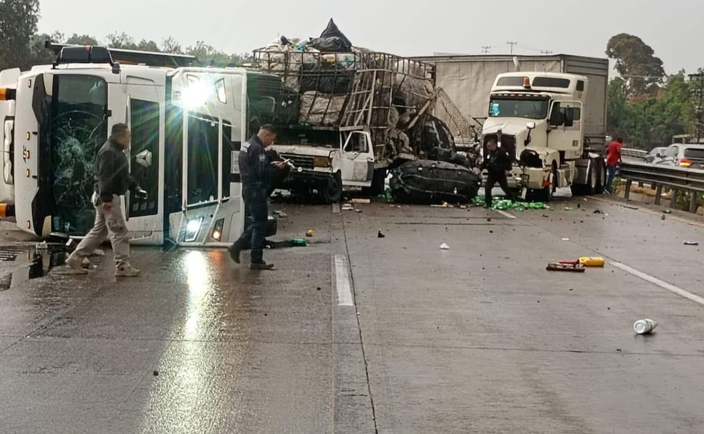 La unidad volcada transportaba camionetas nuevas de la marca Kia, las cuales presentaron daños tras el impacto en Coyotepec. Foto Especial