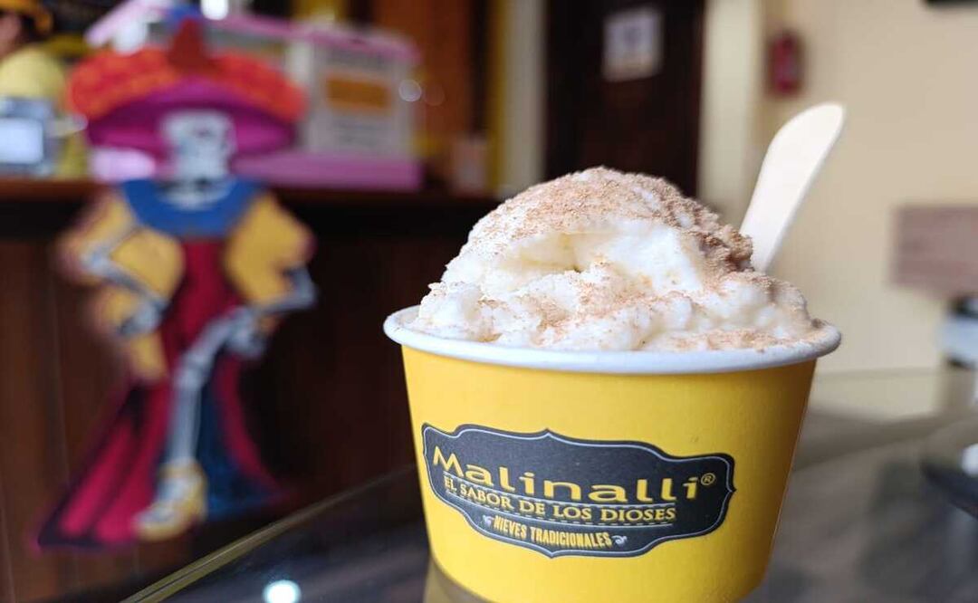 Imagen de un cono de nieve de pan de muerto con canela, listo para ser degustado, en la nevería Malinalli en Toluca, Edomex.