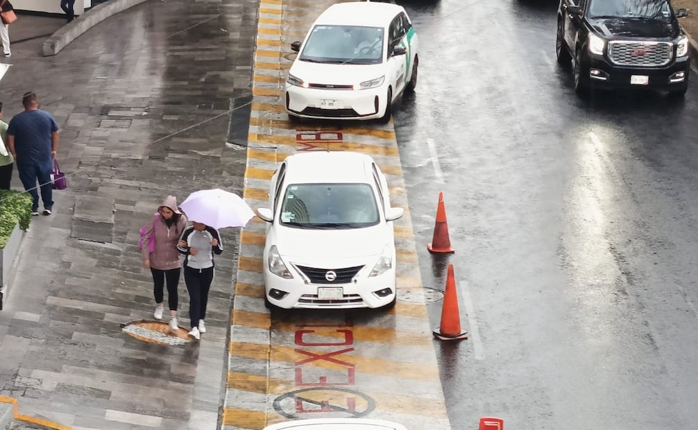 Peatones en Naucalpan buscan refugio tras la intensificación de la lluvia esta tarde de martes. Foto Gisela González / El Universal