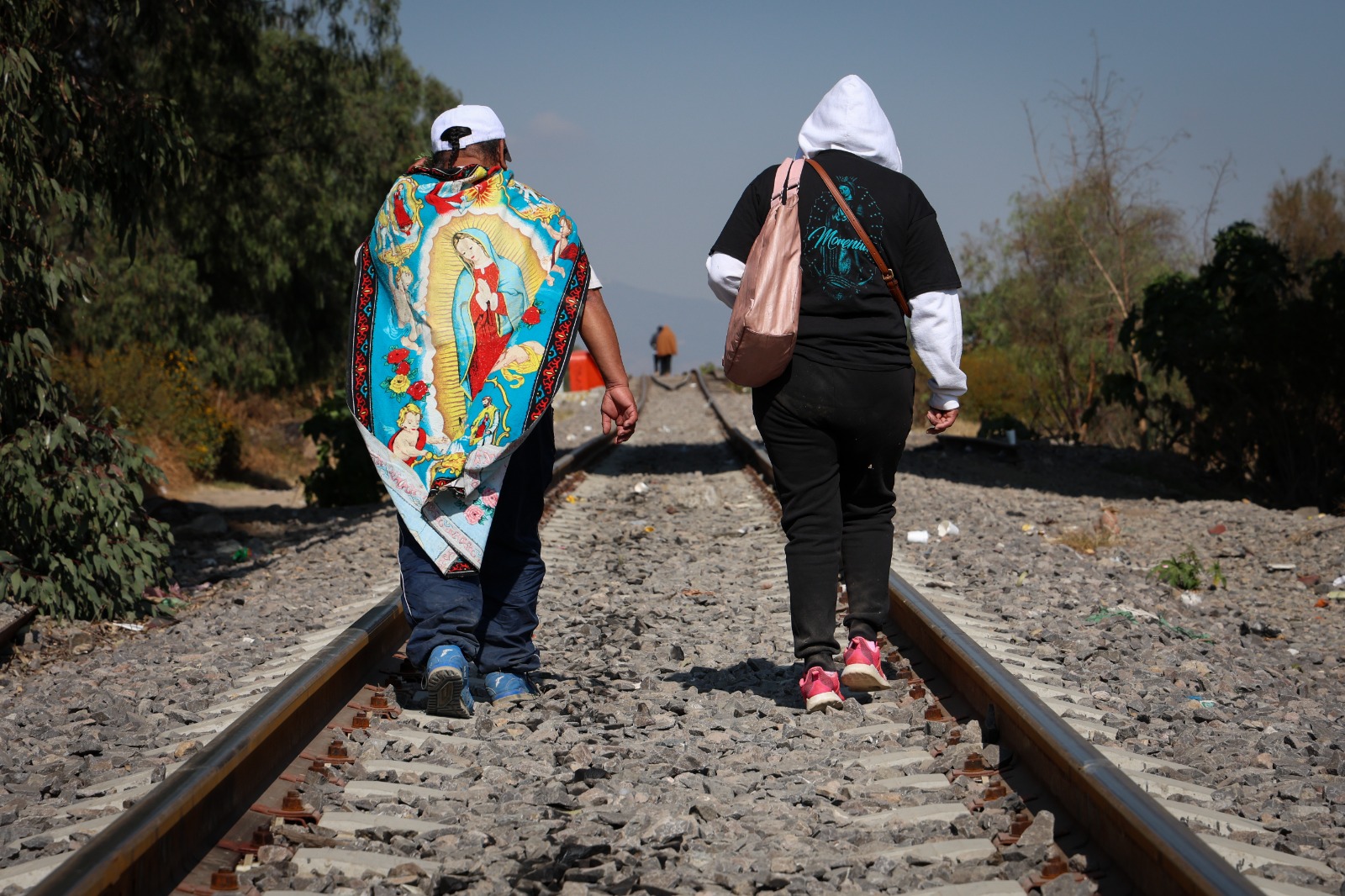 Peregrinos caminan por vías del tren en Nezahualcóyotl