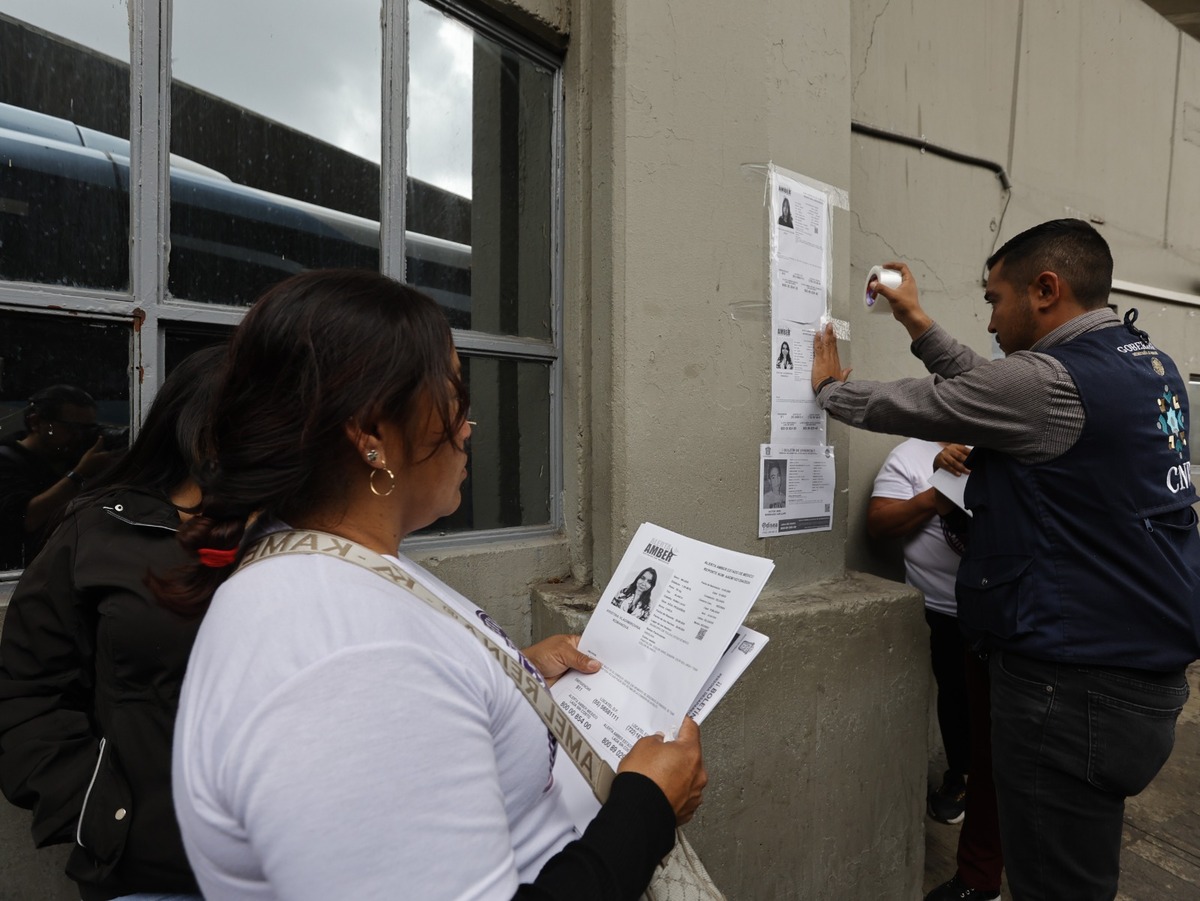 Activistas y madres de personas desaparecidas en el Estado de México, pegan carteles con información de sus seres queridos en la Terminal de Autobuses de Toluca.