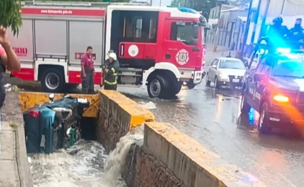 Elementos de Protección Civil y bomberos de Tlalnepantla maniobraron en el canal para asegurar el vehículo volcado. Foto Especial