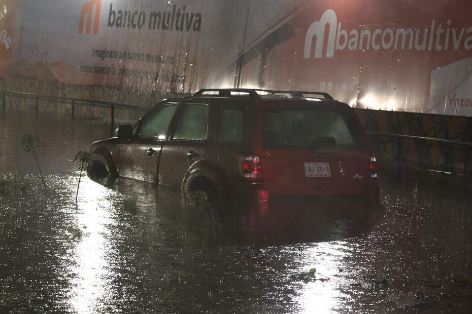 Una familia, que incluía a un bebé, tuvo que abandonar su camioneta en Avenida Lomas Verdes al quedar completamente atrapada por la inundación. Foto Valente Rosas / El Universal