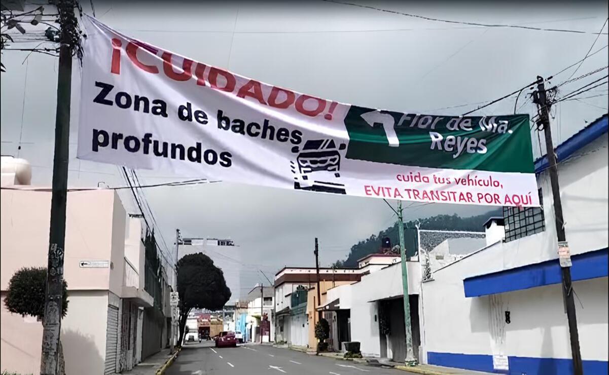 La lona ubicada en la calle de Plutarco González emite un mensaje ¡Cuidado! Zona de baches profundos en la calle Flor de María Reyes, cuida tu vehículo y evita transitar por aquí. Foto: Macrina Vázquez