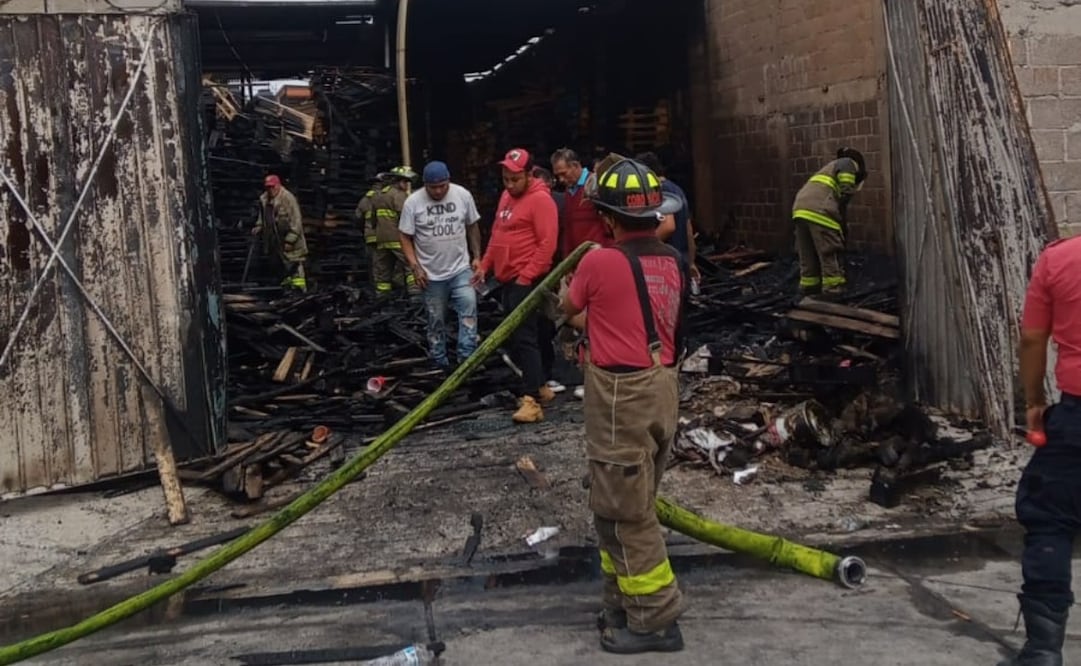 Elementos de bomberos combaten el fuego que consumió una bodega de tarimas en la colonia Libertad durante la madrugada de este lunes. Foto Especial