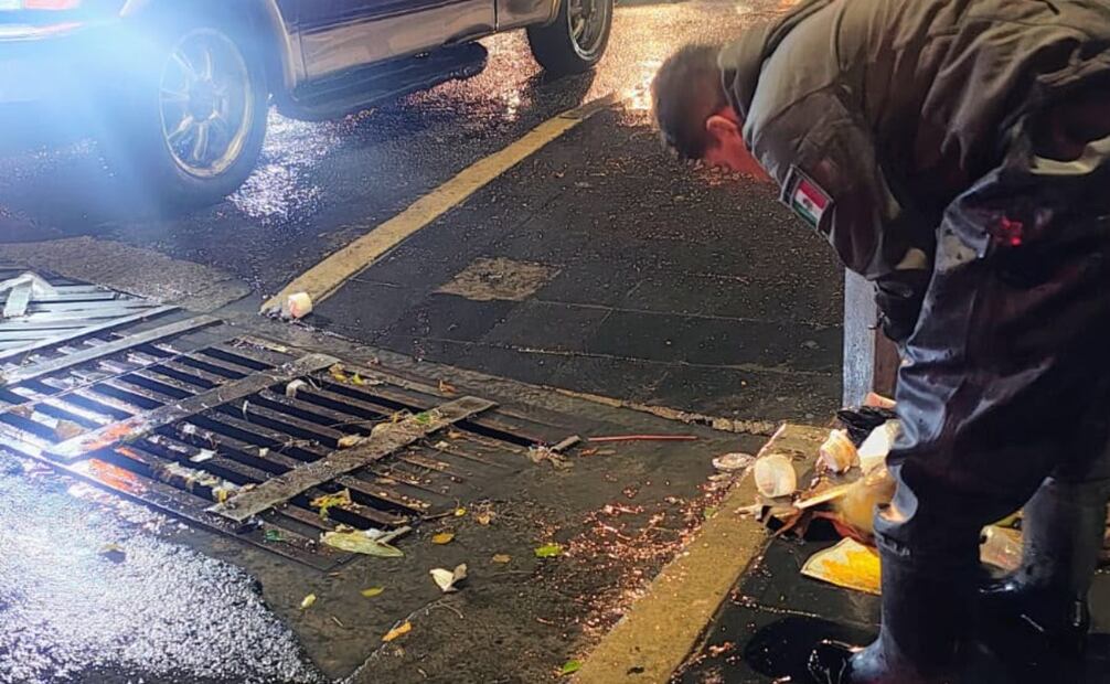Cuadrillas municipales limpiando rejillas de tormenta obstruidas por residuos para evitar inundaciones. Foto Especial