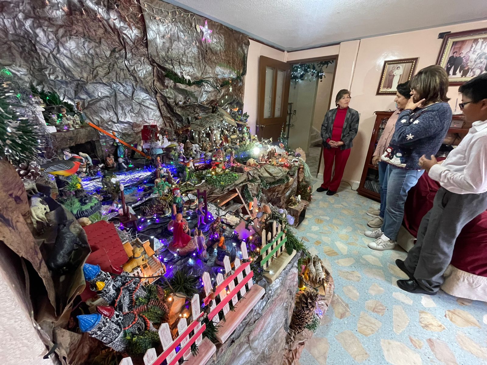 Familias reunidas alrededor del nacimiento, admirándolo con asombro y alegría. Foto Michelle Sánchez