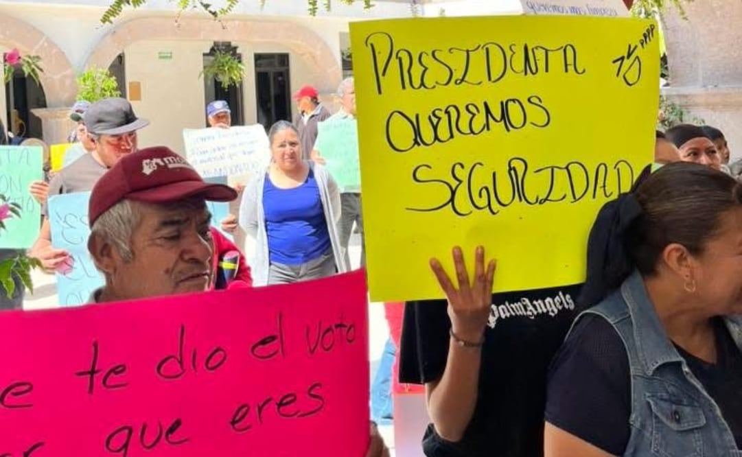 Con cartulinas en mano, locatarios de Coyotepec alzan la voz frente al Palacio Municipal. Foto Especial