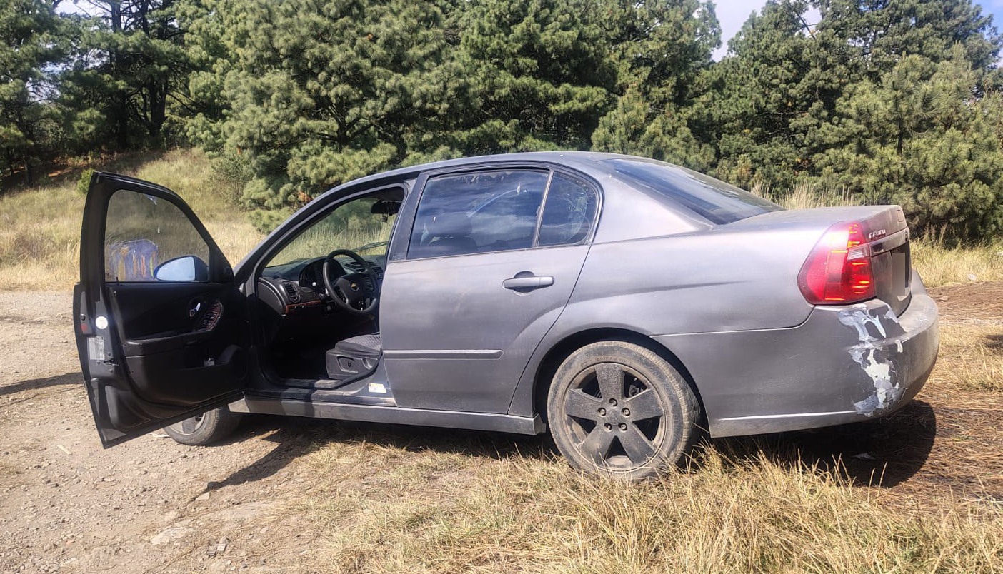 Los uniformados aseguran la camioneta robada, un Chevrolet Malibu (vehículo de asalto) y una Ford F250 (usada para la descarga) en Joquicingo. Foto Especial