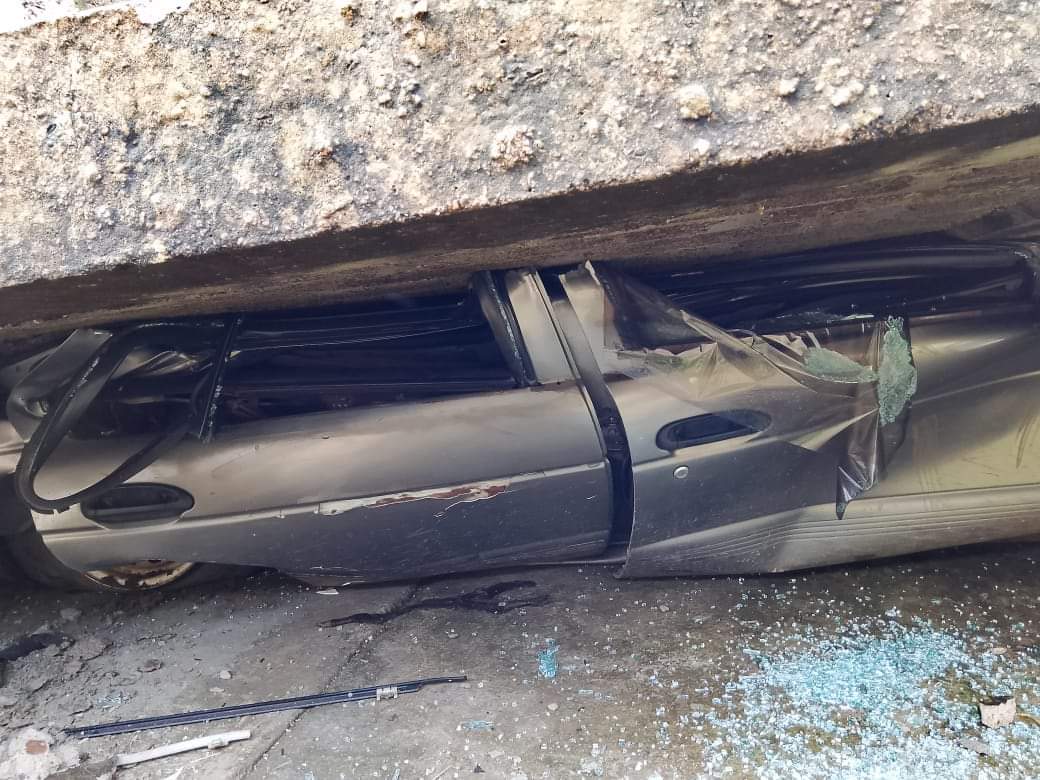 Un vehículo Nissan tipo Tsuru de color gris quedó debajo de la barda. Foto Especial